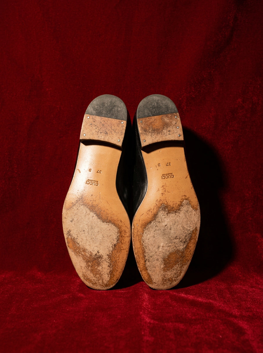 Gucci loafers sole detail showing size 37 B on red editorial backdrop