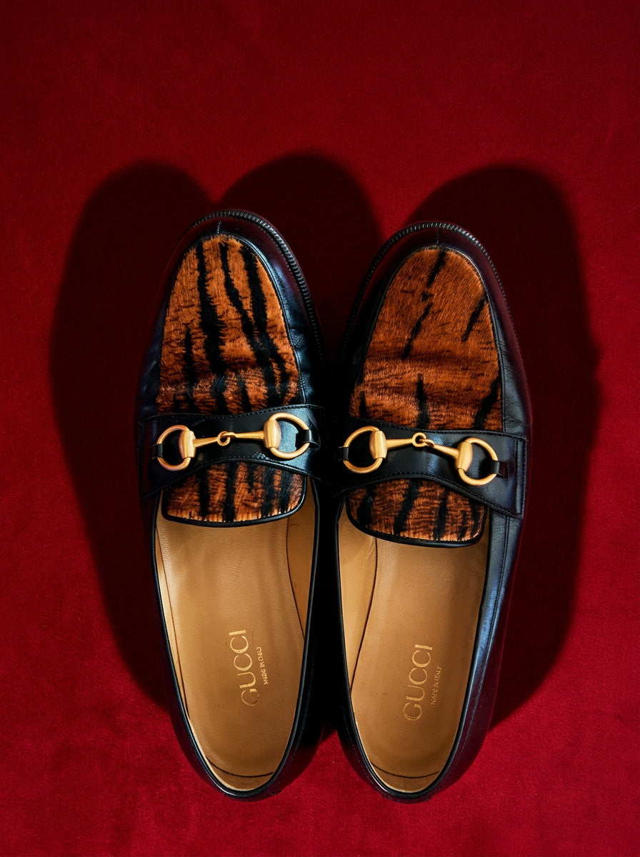 Gucci horsebit loafers top view on red editorial backdrop